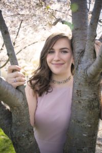 a spring portrait of a young girl with a blossoming tree