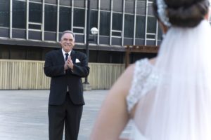 a father seeing his daughter in her wedding dress for the first time