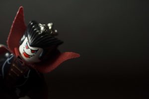 a vampire lego emerges from a dark background